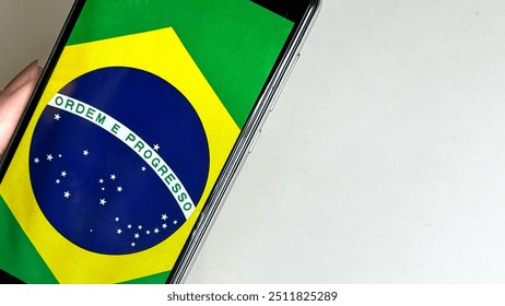 Photograph the National Flag of Brazil with your smartphone. Brazilian flag, symbol of the country. - Powered by Shutterstock