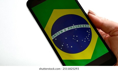 Photograph the National Flag of Brazil with your smartphone. Brazilian flag, symbol of the country. - Powered by Shutterstock