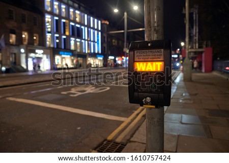 Photograph of the push button of a traffic light warning that you still have to wait to cross the street. Princess Street, Edinburgh, Scotland. 1-1-2020