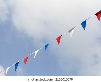 Photograph of red white and blue triangular bunting on sky background. Queen Elizabeth's Jubilee 2022.