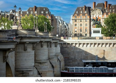 Photograph of the Royal Bridge of Paris over the beautiful Seine River under a beautiful blue sky, creating a beautiful contrast, scenery and background with the Parisian city.
