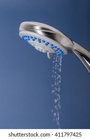 Photograph of a shower head showing drops and streams of water, ideal concept for domestic water usage