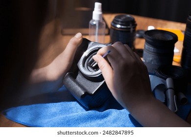 Photograph of unrecognizable person cleaning a camera sensor. - Powered by Shutterstock