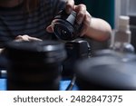 Photograph of unrecognizable woman cleaning a camera lens. Concept of photography.