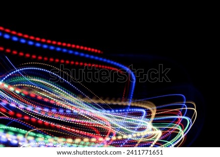 A photograph of vibrant multi-color dotty lights in a long exposure photo against a black background. Light painting photography