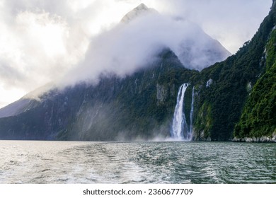 Photograph of Waterfalls from a boat on a misty and rainy day in Milford Sound in Fiordland National Park on the South Island of New Zealand - Powered by Shutterstock