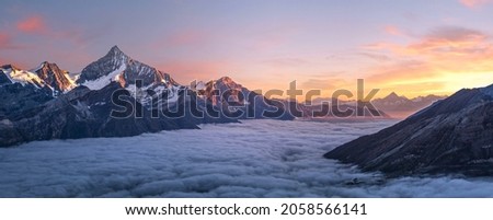 Photograph of white fog with mountains on the side in the evening.