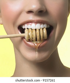 Photograph of woman's teeth honey utensil.