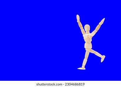 Photograph of a wooden mannequin with blue background, it is in motion, with arms open and stretched upwards. Photo to be able to cut out. Concepts. Selective focus. Space for copy - Powered by Shutterstock