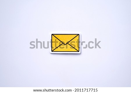 Photograph of yellow message, notification or envelope icon against white background. Table top view, flat lay, copy space.