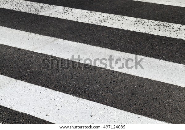   photographed
close-up of road marking is located on the roadway, white lines of
a pedestrian crossing