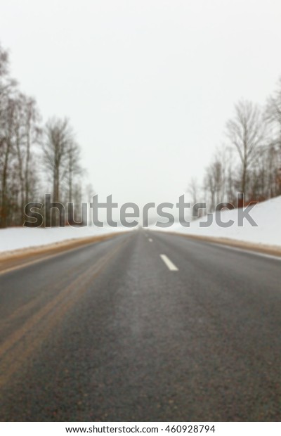  photographed close-up of the road for the\
movement of vehicles covered with snow, winter season, countryside,\
empty roadway, defocused