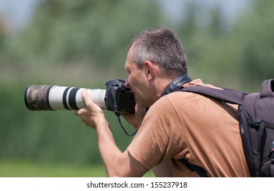 Photographer In Action With  Telephoto Lens