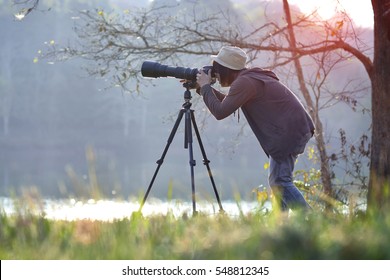 Photographer In Action With Telephoto Lens At Morning Light