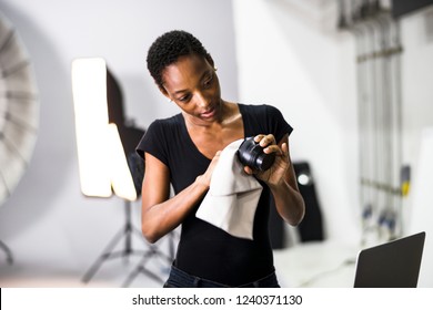 Photographer assistant cleaning a lens - Powered by Shutterstock