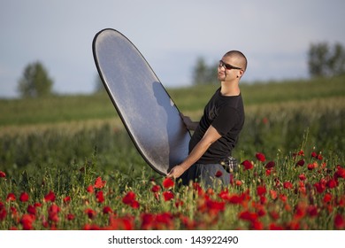 Photographer Assistant Holding Reflector In A Poppy Field