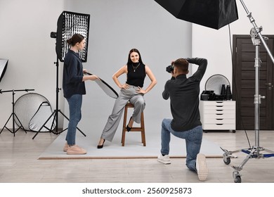 Photographer and assistant working with model in professional photo studio - Powered by Shutterstock