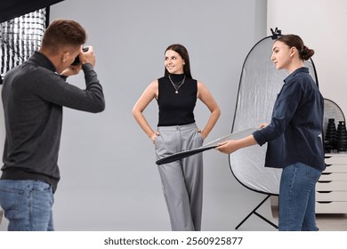 Photographer and assistant working with model in professional photo studio - Powered by Shutterstock