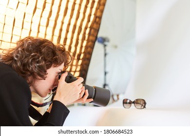 Photographer with camera photographs a pair of glasses for product photography - Shutterstock ID 1806684523