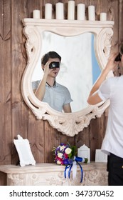 the photographer with the camera is reflected in a mirror