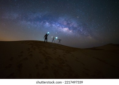 Photographer Camping in the sand dune desert  with milky way star of Abu Dhabi, UAE.