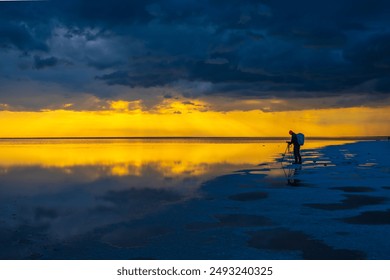 Photographer captures the mesmerizing sunset and its reflection over calm waters, creating a beautiful and tranquil scene. - Powered by Shutterstock
