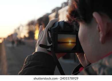 Photographer capturing sunset over river - Powered by Shutterstock