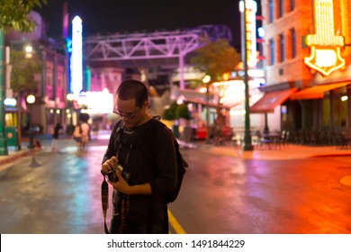 Photographer Check Old Camera In City And Neon Lights At The Night