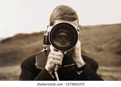 Photographer. Close up portrait of man holding vintage photo camera. young man using retro camera outdoor