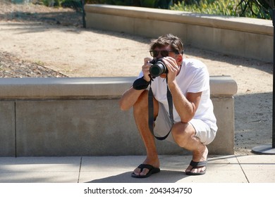 Photographer Crouching Low To Take Photo