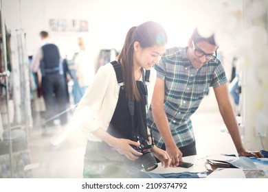 Photographer and fashion designer viewing proofs in sunny office - Powered by Shutterstock