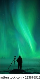 Photographer with his camera and tripod taking pictures of Northern Lights. Aurora Borealis over snowy winter landscape. - Shutterstock ID 2238965121
