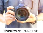 Photographer holding DSRL camera in his hands with talking pictures outdoors