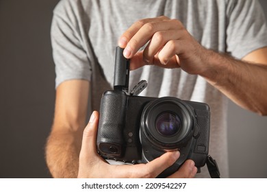 Photographer inserting battery to the camera.