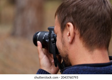 The photographer looking through the viewfinder of a digital camera. The concept of the photography process. Selective soft focus. The photographer takes pictures of nature, landscapes