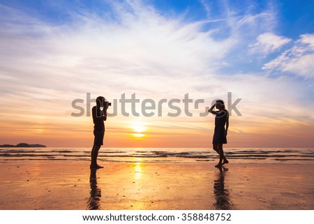 photographer and model, beach photo shooting at sunset, man taking pictures of woman