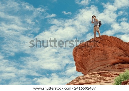 Photographer in mountains against the dramatic sky