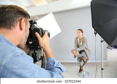 Photographer on a shooting day in studio with model - Powered by Shutterstock