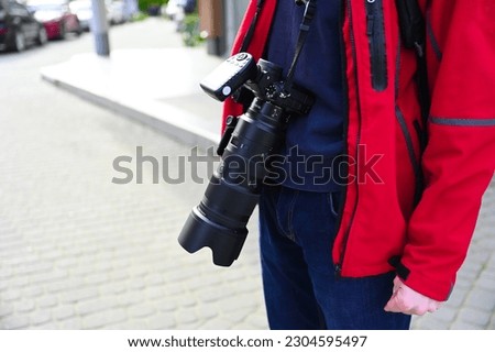 A photographer is seen capturing images in an urban setting, perhaps focusing on the unique architecture or bustling street scenes. They appear focused and passionate about their craft