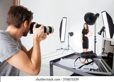 Photographer shooting model in studio with softboxes - Shutterstock ID 376873339