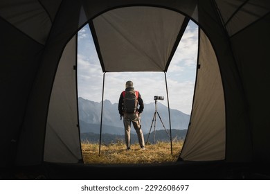 Photographer standing in front of a camping tent. Travel concept adventure active vacations outdoor - Powered by Shutterstock