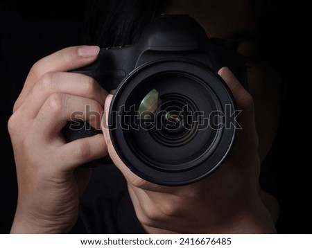 photographer take pictures Snapshot with camera. man hand holding with camera looking through lens.Concept for photographing articles Professionally.