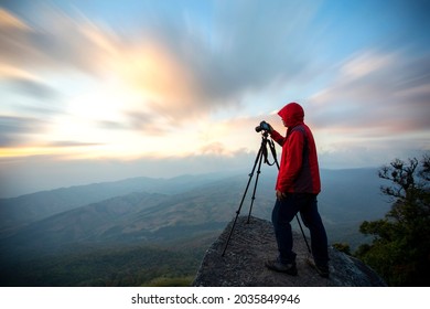photographer taking a beautiful picture of landscape during sunset period on the view point