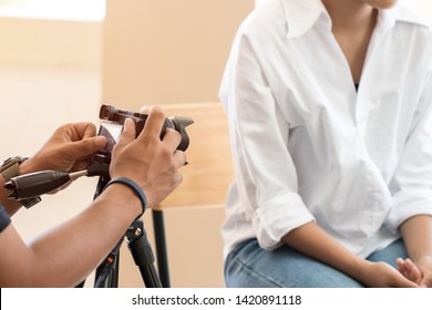 Photographer taking camera with Happy young Asian woman beauty blogger or vlogger recording video viral clip at home for singing live and sharing online mass media by mirrorless camera on tripod
