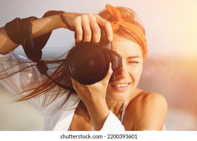 Photographer taking photo with professional camera near sea - Powered by Shutterstock