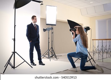 Photographer taking picture of  model in studio - Powered by Shutterstock