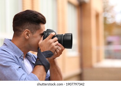 Photographe prenant une photo avec caméra professionnelle à l'extérieur