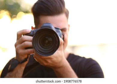 Photographer Taking Picture With Professional Camera In Countryside, Focus On Lens