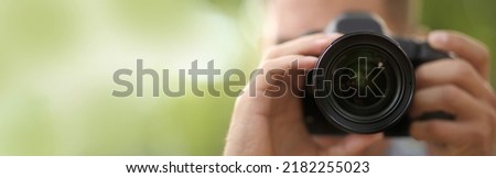 Photographer taking picture with professional camera outdoors, space for text. Banner design