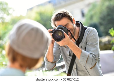 Photographer Taking Picture Of Trendy Model In Park